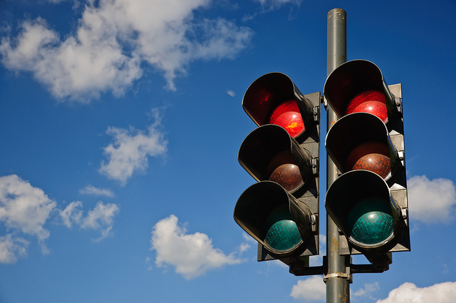 A couple of red traffic lights against a blue sky by Horia Varlan